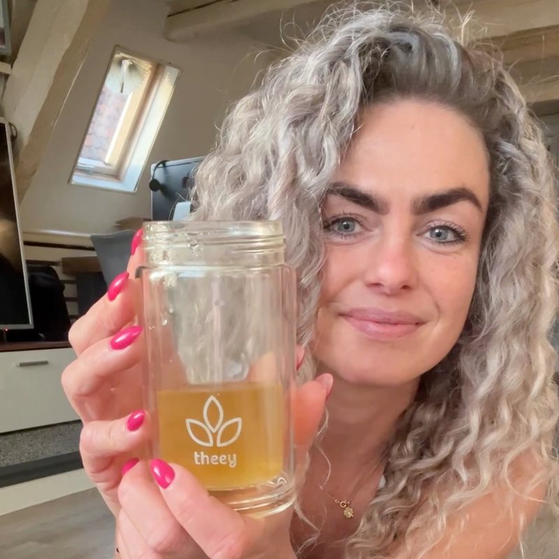 Theey-klant met een theefles met gouden thee